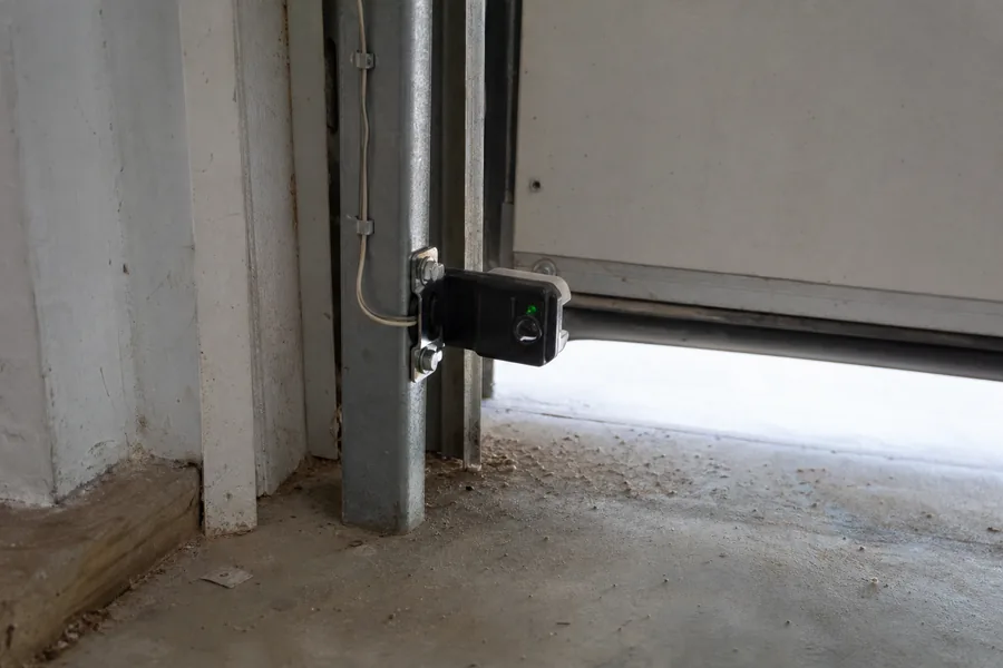 Photo-eye safety sensor at the base of a garage door track in Pittsburgh, PA